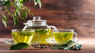 A kettle and cup full of green tea