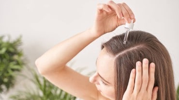 Woman applying hair serum