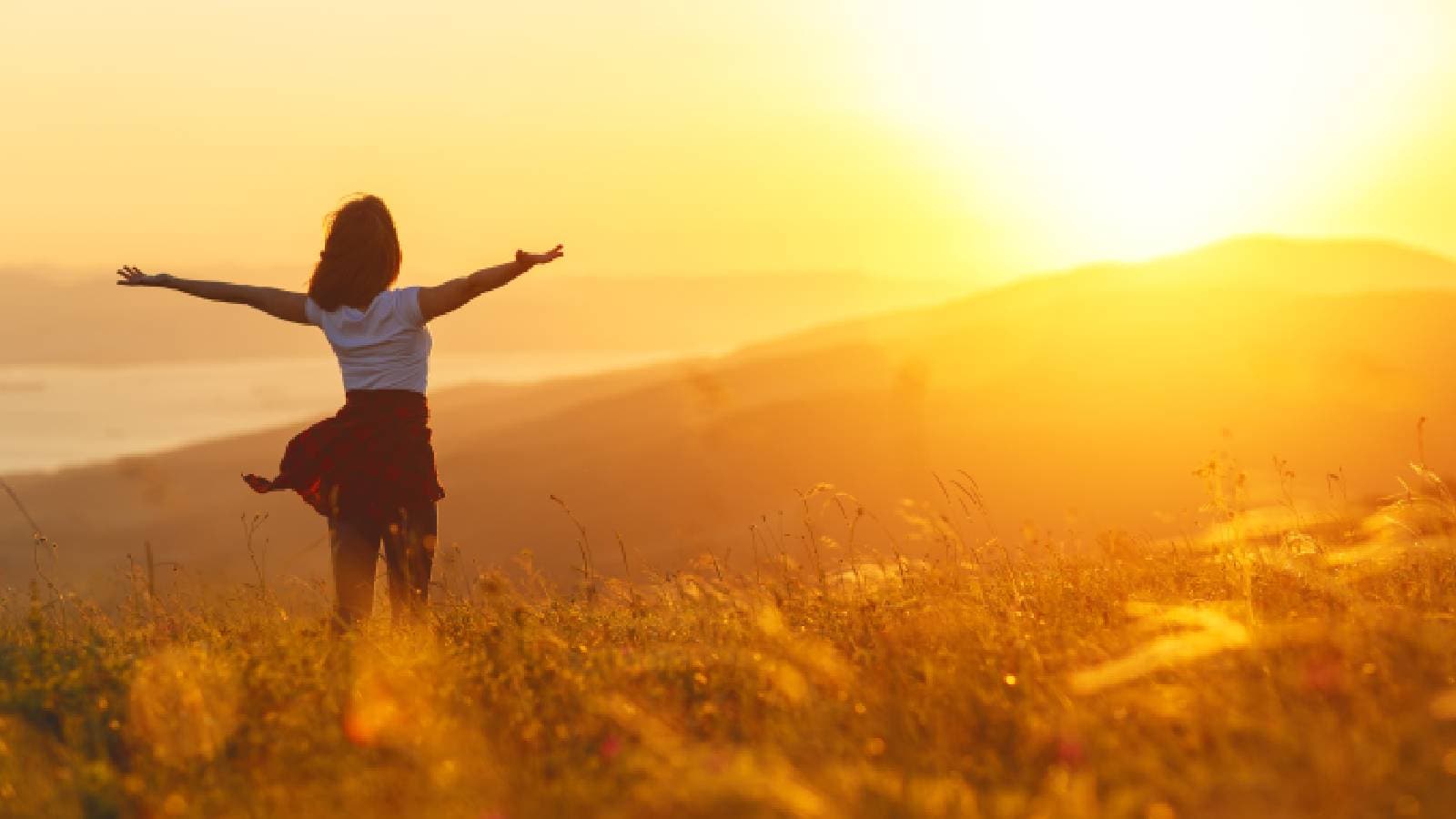 A woman with arms wide open looking ahead