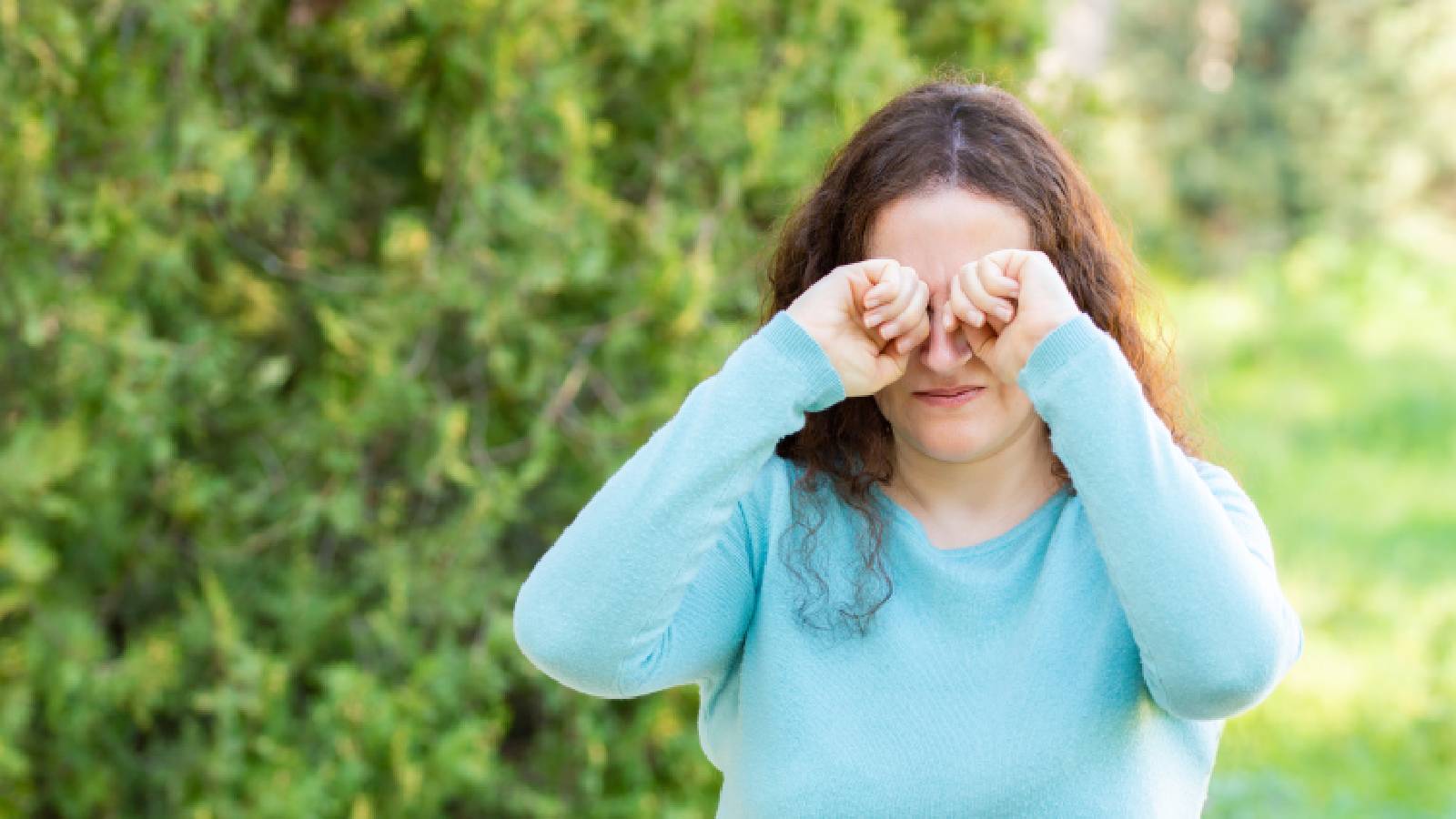A woman rubbing her eyes