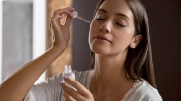 A woman applying serum on her face