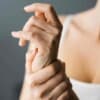 Woman holding her wrist before doing yoga for wrist pain